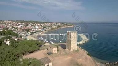 鸟瞰中世纪塔在NeaFokea海滩和一艘小船在港口，Halkidiki希腊，前进